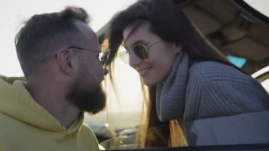 Olumlu gülümseyen genç bir çift aşık bir erkek ve kadın öpüşüyor.