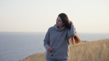 Dışarıda kameraya poz veren kazaklı güzel bir kadın.