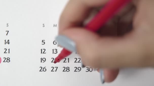 Femme cercle de main jour dans la date du calendrier avec un marqueur rouge. Business Basics Planificateur et organisateur de calendrier mural. 27 AVRIL — Video
