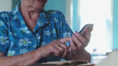 Mavi bornozlu yaşlı kadın telefon numarasını çevirir ve doktoru arar.