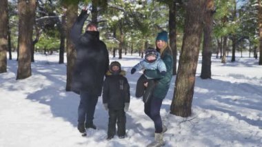 Genç, mutlu bir aile babası, kameraya poz veren küçük çocukları olan bir anne.