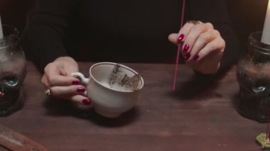 Cadı kadın falcıya yakın çekim kahve fincanı tutuyor ve kaderi okuyor.