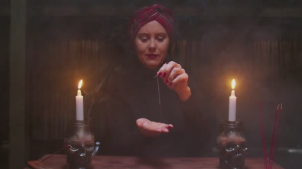 Velha mulher sênior cartomante usa agulha com fio para ritual de adivinhação mágica — Vídeo de Stock