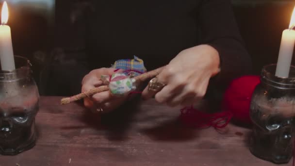 Κοντινό πλάνο της γυναίκας μάντισσα χρησιμοποιεί βουντού κούκλα και κόκκινο σχοινί σε τρομερό μαγικό τελετουργικό — Αρχείο Βίντεο