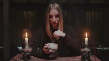 Genç cadı kadın falcı elinde kahve fincanı tutuyor ve kaderi okuyor.