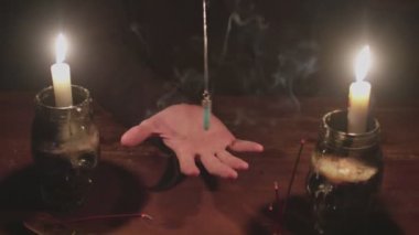 Gizemli büyücü erkek falcıya yakın çekim. Gelecekteki ayinlerinde mavi sihirli kristal kullanıyor.