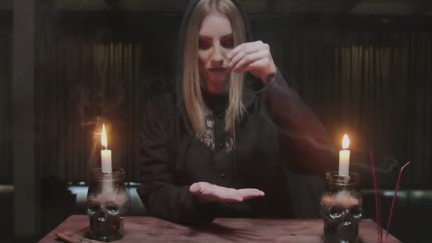 Молода відьма-жінка використовує голку з ниткою до магічного ритуалу ворожіння — стокове відео