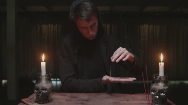 Concentrato misterioso mago indovino maschio utilizza ago con filo al rituale di divinazione magica — Video Stock