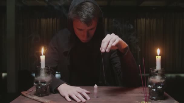 Magicien mystérieux concentré diseur de bonne aventure masculine utilise aiguille avec fil et cristal magique sur la table dans le rituel de divination magique — Video