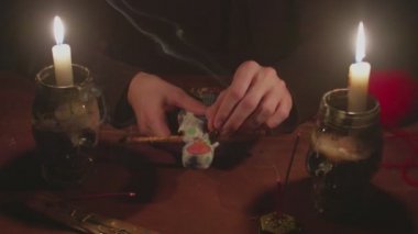 Gizemli büyücü erkek falcı korkunç bir büyü ritüeliyle kara bebeğe iğne batırıyor.