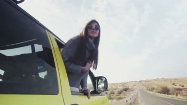 Uzun kulaklı genç bir kadın arabanın camından dışarı sarkmış.