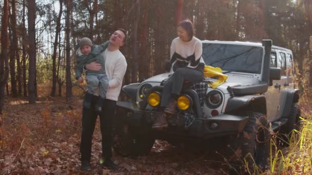 幸せな若い家族が一緒に秋の森の中で時間を過ごす — ストック動画