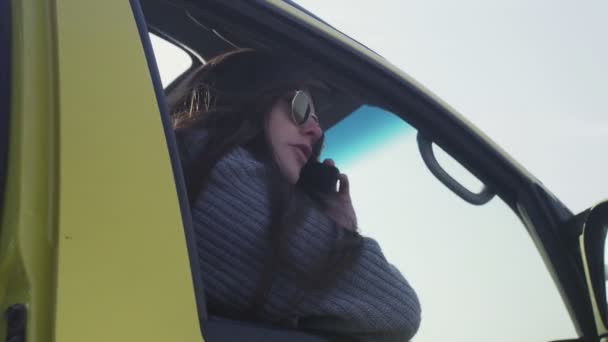 Κοντινό πλάνο της νεαρής γυναίκας κάθεται μόνη της στην κονσέρβα και μιλάει στο τηλέφωνο — Αρχείο Βίντεο