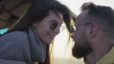 Olumlu gülümseyen genç bir çift aşık bir erkek ve kadın öpüşüyor.