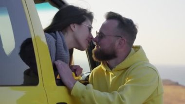 Olumlu gülümseyen genç bir çift aşık bir erkek ve kadın öpüşüyor.