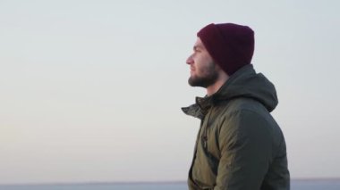 Yürüyüş hobisi. Kırmızı şapkalı sırt çantalı yalnız adam deniz gibi görünüyor.