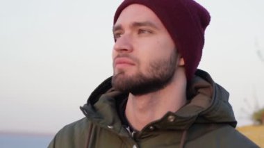 Yürüyüş hobisi. Kırmızı şapkalı sırt çantalı yalnız adam deniz gibi görünüyor.