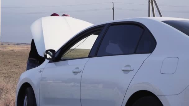 Hombre tratando de reparar su motor, hombre joven de pie en el coche roto preocupándose por el estrés. — Vídeo de stock