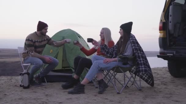 Jeunes amis heureux campeurs assis près de la tente et la voiture, boit un thé chaud — Video