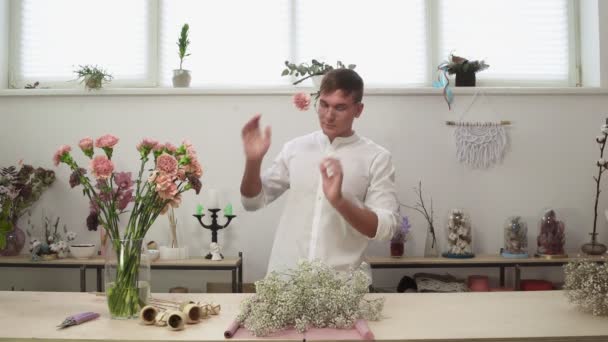Молодий чоловічий флорист в окулярах робить красивий і стильний букет зі свіжих квітів у квітковій дизайнерській студії . — стокове відео
