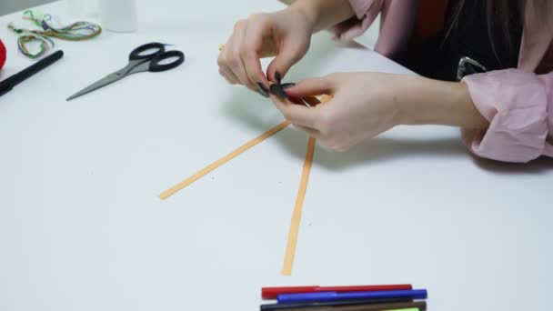 Vista superior de la mujer hace una artesanía de un papel amarillo y pegamento en la mesa en un estudio blanco — Vídeos de Stock