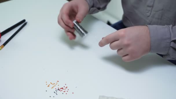 Top view of man unwinds a metal line and prepares it for beading at the table — Stock Video
