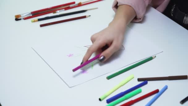 Mujer joven atractiva utiliza lápices de colores para dibujar un cuadro en un papel blanco en la mesa — Vídeos de Stock