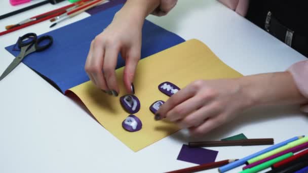 Blisko kobiety robi rzemiosło z kolorowego papieru i kleju przy stole — Wideo stockowe