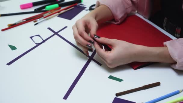 ท็อปวิวของผู้หญิงสร้างงานฝีมือจากกระดาษสีม่วงและกาวที่โต๊ะในสตูดิโอสีขาว — วีดีโอสต็อก