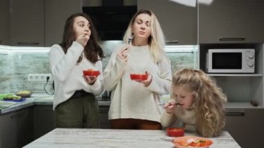 Genç anne ve iki kızı az önce mutfakta sebze salatası pişirdiler..