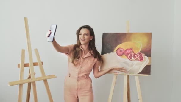 Mooie kunstenaar maakt record video verhalen met haar een nieuwe foto in haar atelier — Stockvideo