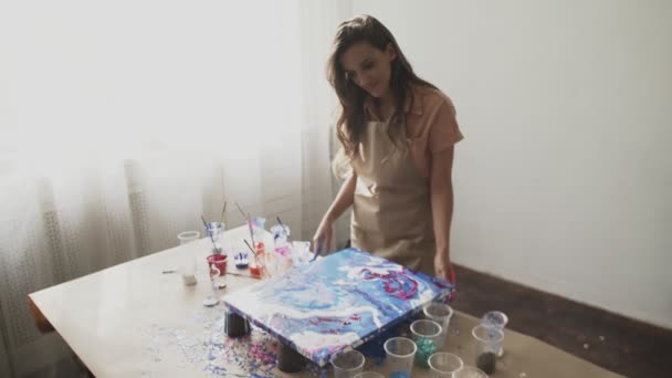 젊은 아름다운 여성 미술가가 색깔을 준비하고 유체 예술의 그림을 그리는 모습 — 비디오