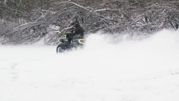 ATV Quad bike à deriva na neve. Piloto dirigindo uma moto quad no campo de neve. — Vídeo de Stock