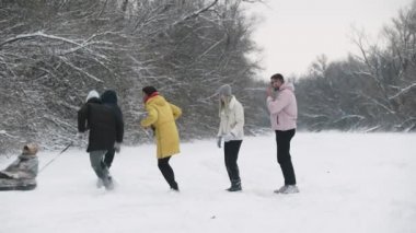 Genç arkadaşlar kış ormanlarında karla eğlenirler.