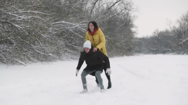 Jeune couple heureux s'amuser avec la neige dans la forêt d'hiver — Video