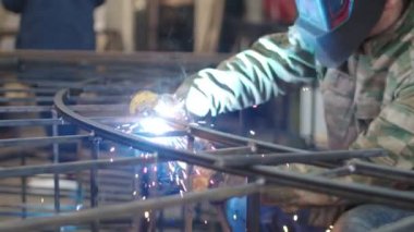 Yetenekli Sanatçı, soyut ve acımasız bir Metal Heykel yapmak için kaynak makinesi kullanıyor