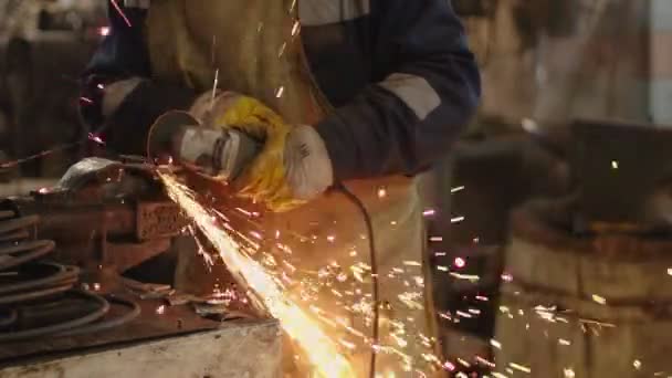 Travailleur utilise meuleuse à disque pour couper une partie métallique de la sculpture — Video