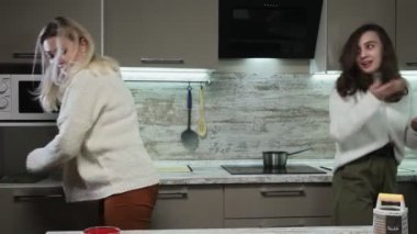 Genç anne ve kızı yemekten sonra mutfağı temizler.