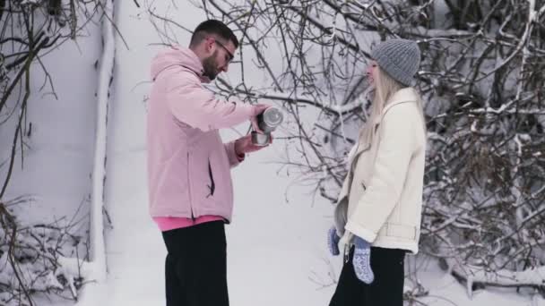 Jeune homme verse le thé d'un thermos à sa petite amie — Video
