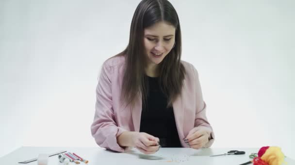 Attraente braccialetto di perline giovane donna a tavola in uno studio bianco — Video Stock