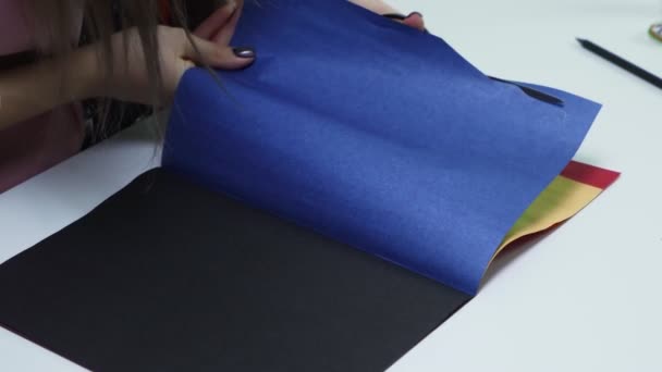 Wanita close-up menggunakan gunting untuk memotong awan kertas berwarna biru di meja — Stok Video