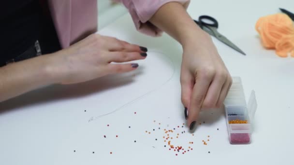 Top kilátás a női gyöngyfűzőt az asztalnál — Stock videók
