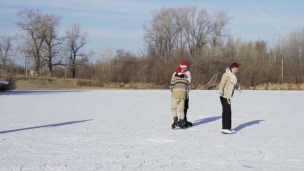 Quatre meilleurs amis dans les chapeaux de Noël Santa chevauchent le patinage sur glace et s'amusent ensemble sur un grand lac gelé dans la forêt — Video