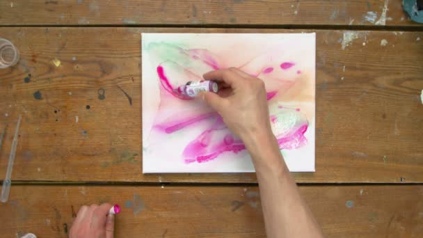 Tampilan atas pelukis gambar abstrak, ia melukis bentuk abstrak dengan cat ungu pada kanvas basah — Stok Video