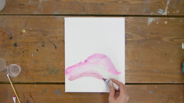 Vista superior da mulher artista pinta um quadro abstrato, ela derrama tinta rosa de tubo em tela molhada — Vídeo de Stock