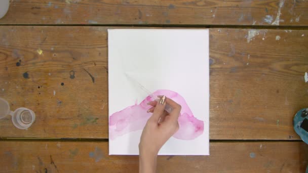 Fluido Art. Pittura astratta colorata. Vista dall'alto dell'artista femminile versa acqua dalla pipetta alla tela e usa il pennello per distribuirla — Video Stock