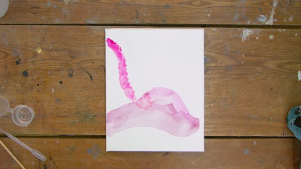 Top view női művész fest egy absztrakt képet, ő önti rózsaszín és piros festékek csövek nedves vászonra — Stock videók