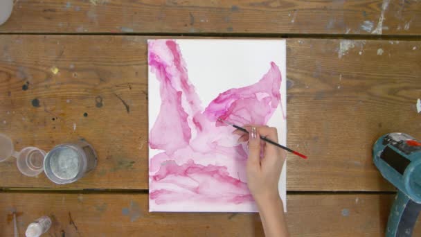 Folyékony művészet. Absztrakt rózsaszín festmény. Top view női művész használ ecset és ezüst festék felhívni egy absztrakt kép — Stock videók