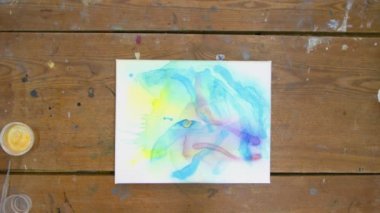 Sıvı Sanat. Soyut resim. Kadın ressamın üst görünümü soyut bir resim çizmek için fırça ve altın boya kullanır