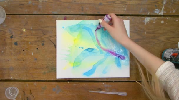 Arte Fluida. Pintura azul e amarela abstrata. Vista superior do artista adiciona uma pintura roxa em uma imagem molhada abstrata — Vídeo de Stock